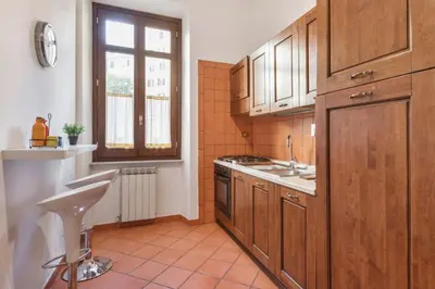 a kitchen with wooden cabinets and a sink and a window at Re Di Roma Vintage Apartment in Rome