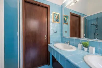 a bathroom with a sink and a wooden door at Re Di Roma Vintage Apartment in Rome