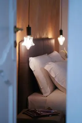 a bedroom with a bed with white pillows and lights at Navona Jacuzzi Apartment in Rome