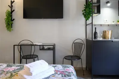 a room with a bed and two chairs and a television at GuestHouse o Affittacamere Magenta Baylon Suite B in Rome