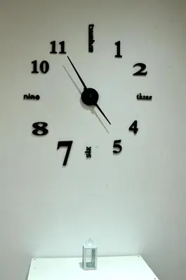 a clock on a white wall with black numbers at Casa di Alberta in Rome