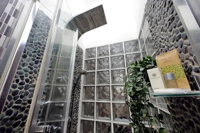 a bathroom with a glass wall with plants in it at Vatican Suites - The Luxury Leading Accommodation in Rome in Rome