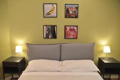 a bedroom with a bed with four pictures on the wall at All You Need is Rome Guesthouse in Rome