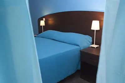 a bedroom with a bed and a nightstand with two lamps at Difronte Ai Musei Vaticani in Rome