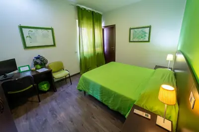 a hotel room with a green bed and a desk at Difronte Ai Musei Vaticani in Rome