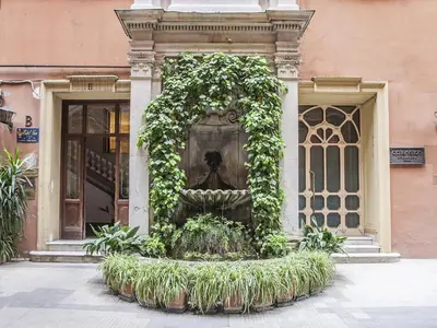 a fountain with plants in front of a building at Hotel Regina Giovanna in Rome