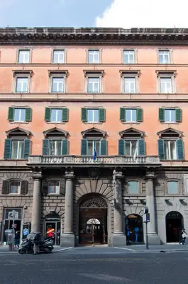 a large pink building with a large entrance at Hotel Regina Giovanna in Rome