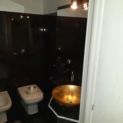 a bathroom with a gold sink and a toilet at Popolo Relax in Rome