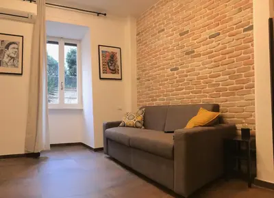 a living room with a couch and a brick wall at Appartamento in via Licia in Rome