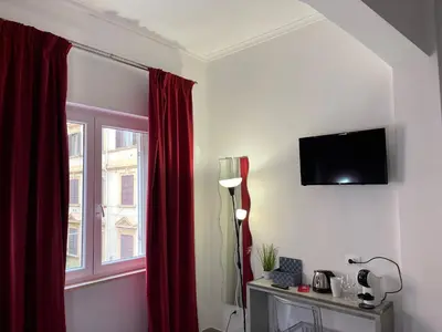 a room with a window and a red curtain at Le Terrazze di San Giovanni in Rome