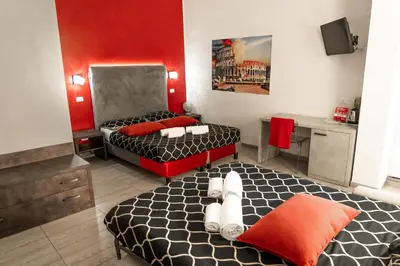 a room with two beds and a desk in it at Le Terrazze di San Giovanni in Rome