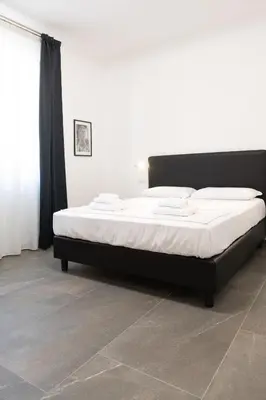 a bedroom with a large bed with white sheets at Inn Urbe Colosseo in Rome