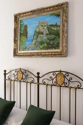 a painting above a bed in a bedroom at Delfini Trevi House in Rome