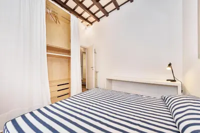 a bedroom with a blue and white striped bed at Campo de' Fiori Apartment in Rome