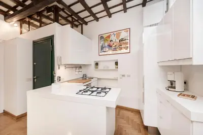 a kitchen with white cabinets and a white counter top at Campo de' Fiori Apartment in Rome