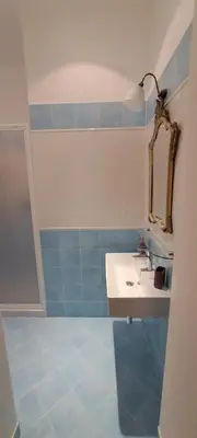 a bathroom with a sink and a mirror and blue tiles at Casa Linnea in Rome