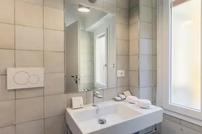 a bathroom with a white sink and a mirror at Trastevere Gallery Suites in Rome