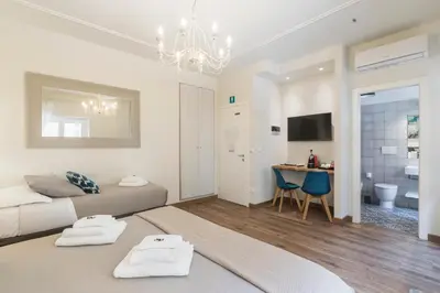 a living room with a bed and a dining room at Trastevere Gallery Suites in Rome
