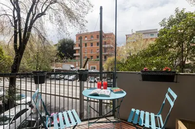 a patio with two chairs and a table on a balcony at Trastevere Gallery Suites in Rome
