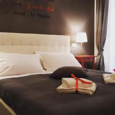 a bedroom with a bed with a red ribbon on it at 109 SUITES ROMA in Rome