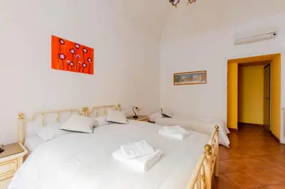 a bedroom with a large white bed with dice on the wall at Oscar 3 in Rome