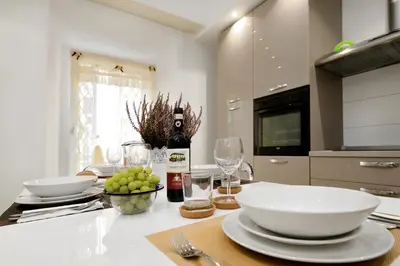 a kitchen with a table with plates and wine bottles at Ludovisi Barberini Grand Apartment in Rome