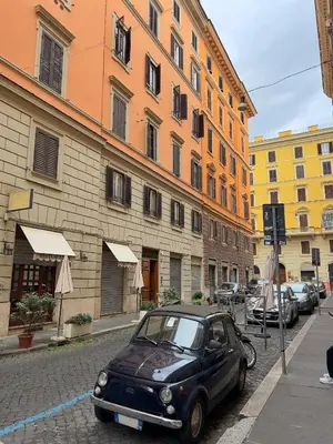 a small car parked on a street next to buildings at Ludovisi Barberini Grand Apartment in Rome