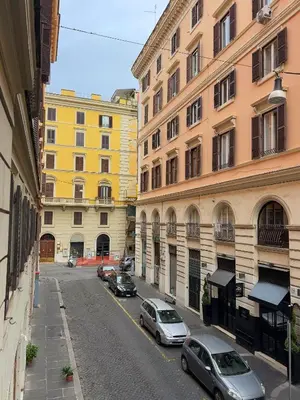a city street with cars parked in front of buildings at Ludovisi Barberini Grand Apartment in Rome