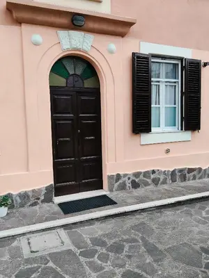 a pink building with a black door and a window at Appartament Piramide Cestia in Rome