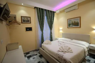 a hotel room with a bed and a television at Quest House Lihong in Rome