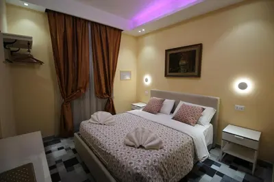 a bedroom with a bed with two pillows on it at Quest House Lihong in Rome