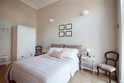 a bedroom with a bed with a pink pillow and a chair at Beautiful suite in the heart of Trastevere in Rome