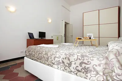 a bedroom with a bed and a desk with a laptop at Angels In Rome in Rome