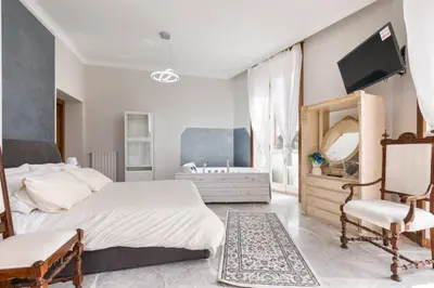 a bedroom with a bed and a mirror and a sink at jacuzzi in front of the colosseum in Rome