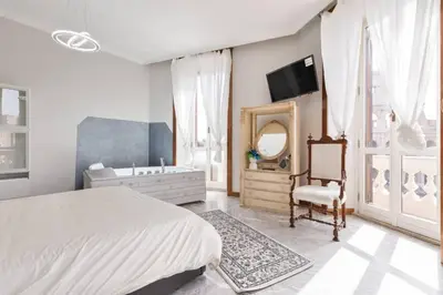 a bedroom with a bed and a tub and a mirror at jacuzzi in front of the colosseum in Rome
