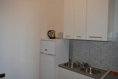 a kitchen with a sink and a refrigerator at Balcony Colosseum View in Rome