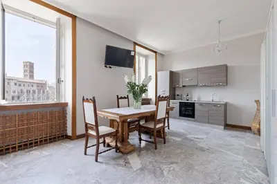 a dining room with a table and chairs and a kitchen at View Colosseo From Jacuzzi in Rome