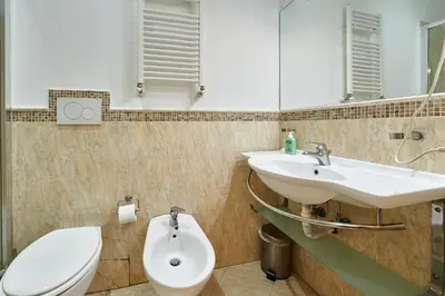 a bathroom with a sink and a toilet and a mirror at Casa al Viminale in Rome