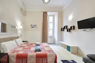 a living room with a bed and a tv at Casa al Viminale in Rome