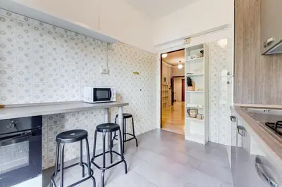 a kitchen with two bar stools and a microwave at BDC - King Termini Apartment in Rome