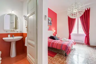 a bedroom with a bed and a sink and a mirror at 2 Passi Al Colosseo B&B in Rome