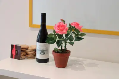 a bottle of wine and a flower on a table at St Peter new and lightsome apartment with balcony in Rome