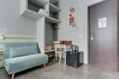 a living room with a blue chair and a table at CAPO D'AFRICA 30 - COLOSSEO in Rome