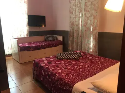 a bedroom with two beds and a flat screen tv at La Casa di Elena in Rome