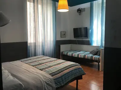 a bedroom with two beds and a flat screen tv at La Casa di Elena in Rome