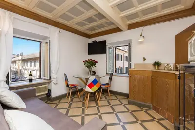 a living room with a kitchen and a table with chairs at Giuditta Suite 121 Trastevere Roma in Rome