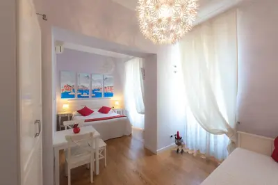 a bedroom with a white bed and a chandelier at Casa Martini in Rome