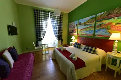 a green room with a bed and a couch at Casa Martini in Rome