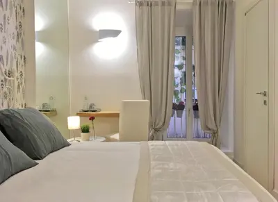 a bedroom with a large white bed and a desk at M SuiteApartment Roma in Rome