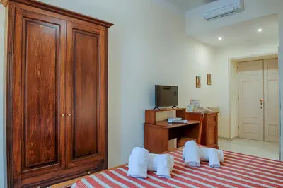 a bedroom with a large wooden cabinet and a bed at Armonia All'Opera in Rome